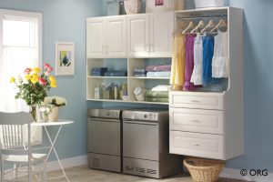 white laundry room shelves and drawers with clothing rack