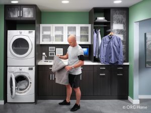 man folding laundry in laundry room