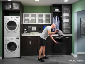 man in laundry room putting item in hamper