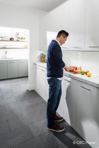 man cutting fruit on white pantry